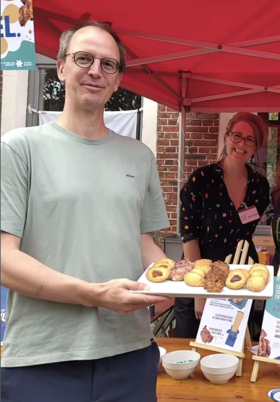 Bram van Bakker Bram met een plateau eigengebakken koekjes en gebak op een markt